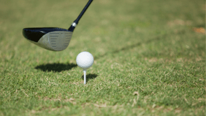 Golf club mid swing on tee