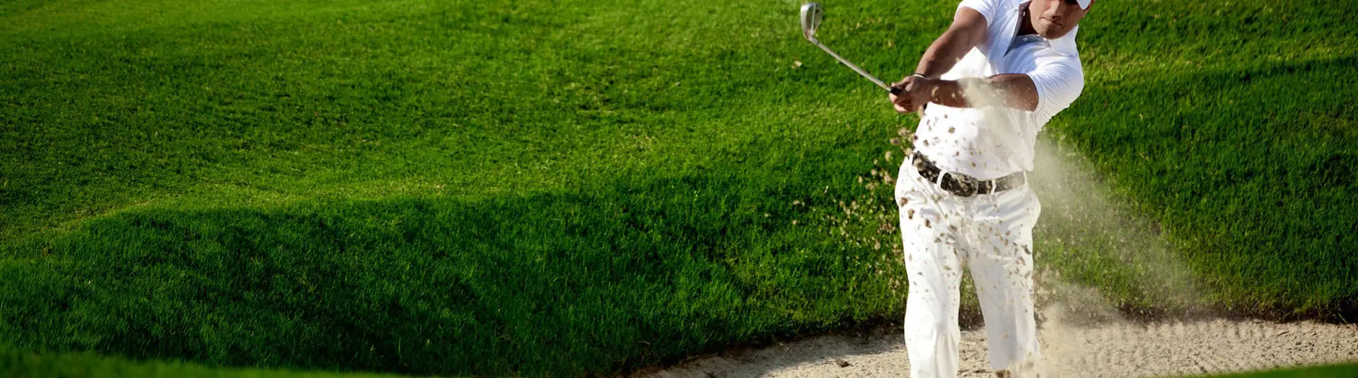 golfer taking swing on course green